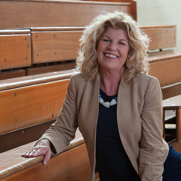 Laura Bishop sits on school bleachers ahead of a client event