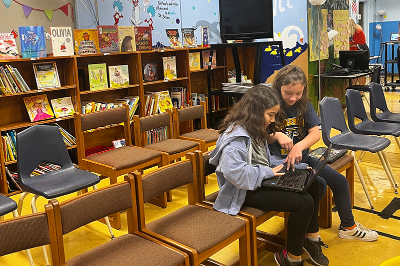 Students use a laptop in Smith School Media Center