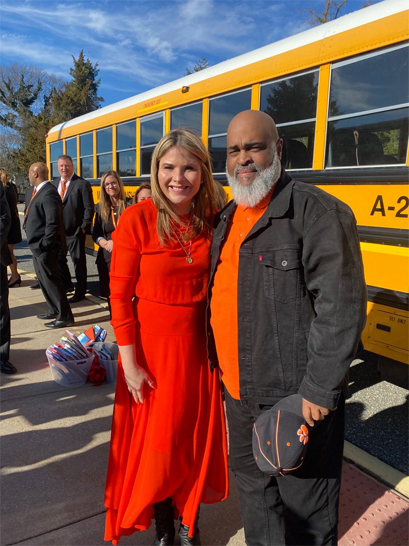 Herman Cruse and Jenna Bush Hager stand in front of Cruse’s bus after Today Show executives awarded the school with book donations.
